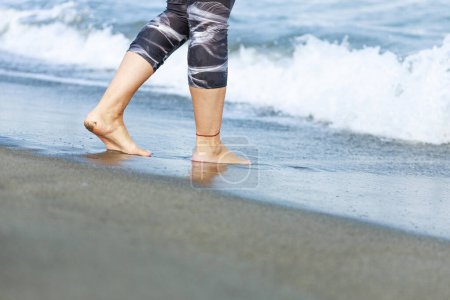 Foto de Mujer joven caminando en la playa - Imagen libre de derechos