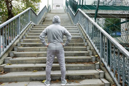 Téléchargez les photos : Jeune homme sportif en vêtements de sport se préparant pour la course d'escalier - en image libre de droit