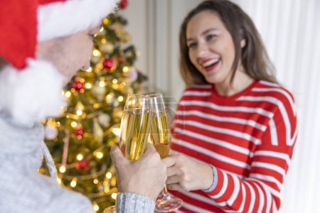 Téléchargez les photos : Jeunes couples buvant du champagne à la veille du Nouvel An dans une belle hom décorée - en image libre de droit
