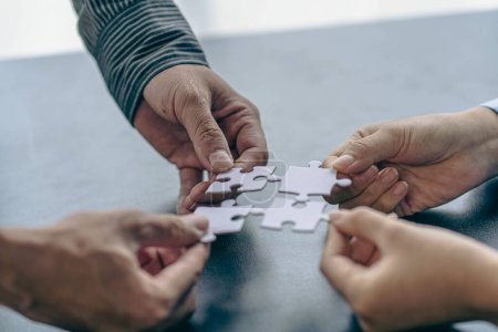 Photo for Businessmen join a jigsaw team. Teamwork and cooperation concept handshake puzzle pieces in the office - Royalty Free Image