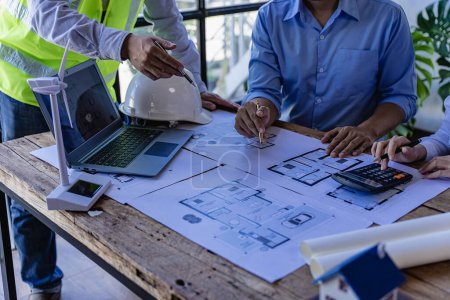 Photo for Engineering team meeting for colleagues discussing and reviewing blueprints at desk in office Engineers and workers planning for construction and renovation building projects in workplace - Royalty Free Image