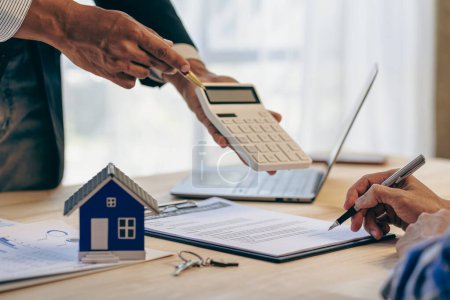 Loan officers recommend homes to clients after signing a real estate contract with an approved mortgage request regarding the offer of mortgage interest rates and home insurance.