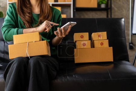 Photo for Small Business Startup SME Owner Asian Woman Checking Online Orders Sell goods, work with boxes. home office freelance work online sme business delivery concept - Royalty Free Image