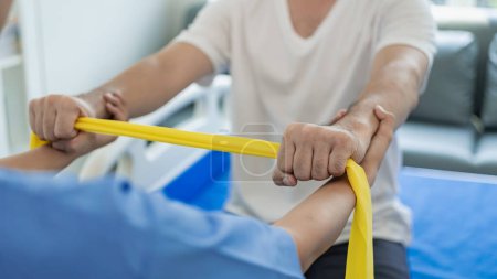 Photo for A doctor or physical therapist works to determine arm treatment, muscle stretching and exercises, doing pain therapy, rehabilitation, effectiveness in the clinic. Close-up pictures - Royalty Free Image