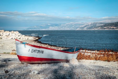 Téléchargez les photos : Bateau abandonné sur la rive du lac d'Egirdir avec montagnes au loin et espace de copie - Région d'Isparta, Turquie 2022 - en image libre de droit