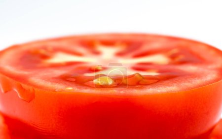 Téléchargez les photos : Tomate rouge tranchée sur fond blanc. Pièce ronde de tomate fraîche. Macro fond - en image libre de droit