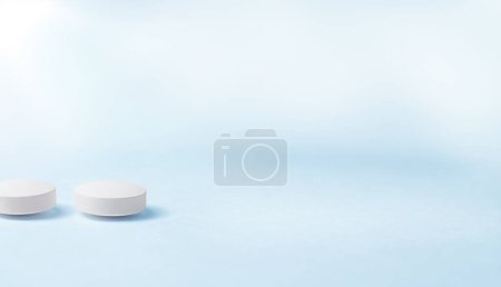 Foto de Dos pastillas blancas tumbadas en una mesa azul. - Imagen libre de derechos