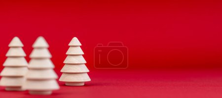 Weihnachten Hintergrund im Vintage-Stil. Weihnachtsbaumschmuck aus Holz auf rotem Hintergrund mit sanftem Schatten. Frohe Weihnachten.