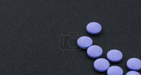 Photo for Purple pills, medicines painkiller. Medications on a black background. - Royalty Free Image