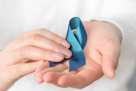 Llevando cinta azul para el mes de concientización sobre el cáncer. Salud y concepto del día mundial del cáncer