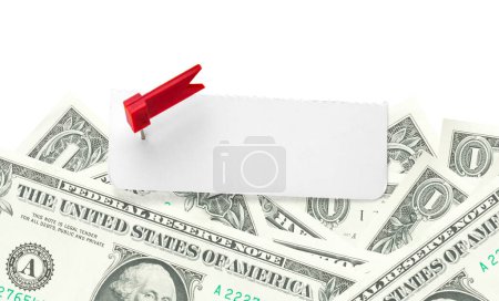 Blank note on a pile of money. Sheet of note paper with push pin on dollars. Cut out and copy space. Paper reminder