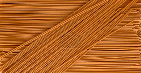 Background of uncooked brown soba noodles. The view from the top. Concept of culinary, food backgrounds