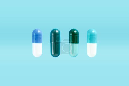 Various two-piece hard starch capsule on blue background with copy space. Biologically active additives. Medical and Health concept