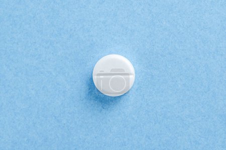 Weiße Tablette auf blauem Hintergrund mit Kopierraum. Gesundheitskonzept