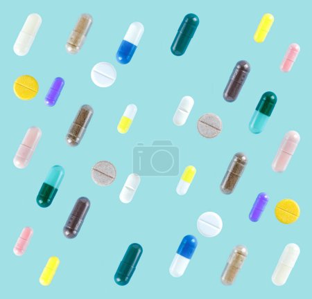 Téléchargez les photos : Modèle sans couture de différentes pilules colorées sur fond bleu doux - en image libre de droit