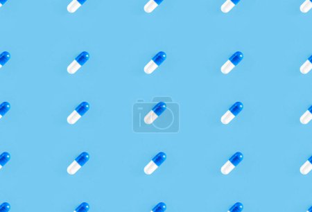 Two-piece pills on blue background. Medical pharmacy seamless pattern.