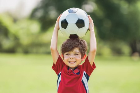 A Young soccer player having fun on a field with ball
