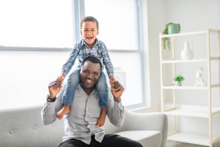Ein glücklicher schwarzer amerikanischer Vater mit kleinem Jungen zu Hause