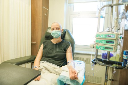 Une jeune femme dans un lit d'hôpital souffrant d'un cancer du sein recevant un traitement
