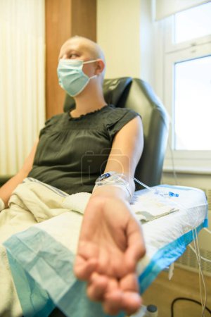 Une jeune femme dans un lit d'hôpital souffrant d'un cancer du sein recevant un traitement