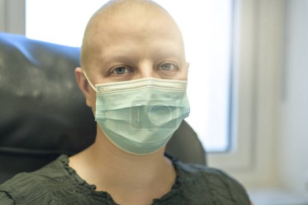 Una mujer joven en cama de hospital que sufre de cáncer de mama que recibe tratamiento