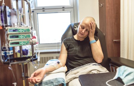 Eine junge Frau im Krankenhausbett, die an Brustkrebs erkrankt ist und behandelt wird, ist traurig
