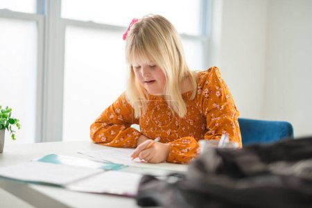 A portrait of a girl with down syndrome drawing and smiling happily while enjoying development class