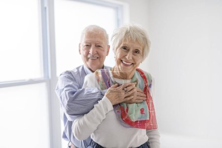 A senior retired couple having great moment together close to a window