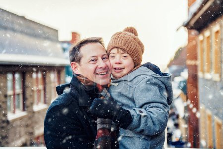 Un padre con un hijo pequeño divirtiéndose juntos al aire libre en un día helado