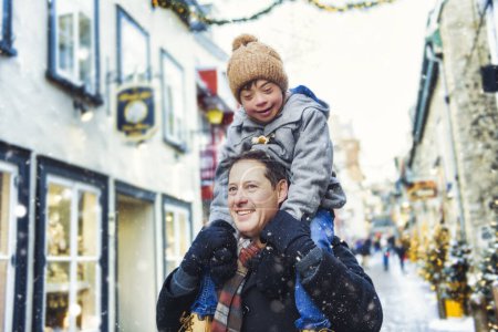 Un padre con un hijo pequeño divirtiéndose juntos al aire libre en un día helado