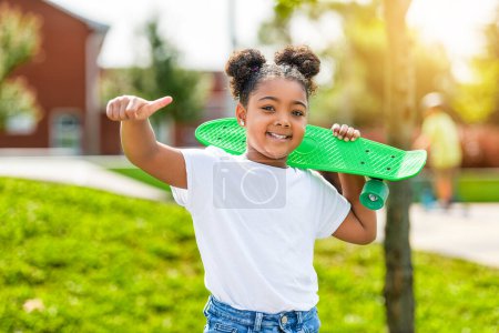 Un niño patinador o niña jugando al skate al aire libre