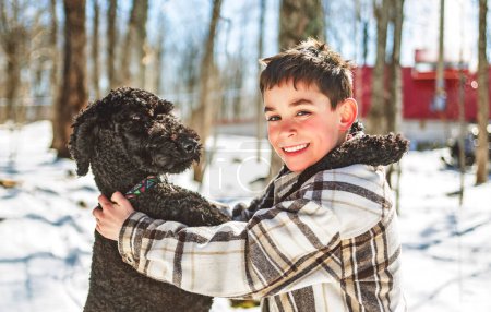 A Cute boy playing with happy Goldendoodle on spring season