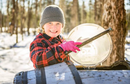 A sugar shack, child having fun at mepla shack forest collect maple water