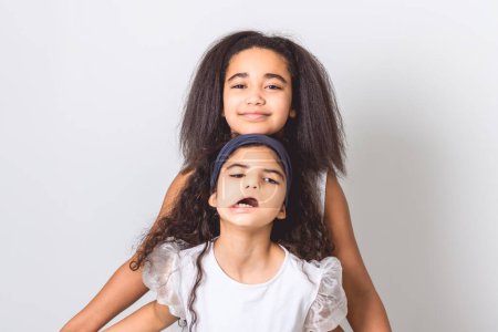 An Adorable 9 years child girl on studio white background with her sister