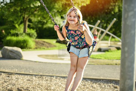 A portrait of child girl having fun at the playground swing