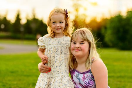 A portrait of child girl outside in summer season at the sunset with a little child friend