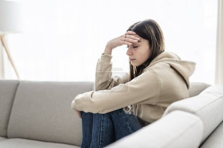 Ein Teenager sitzt zu Hause auf der Couch Frustrierte verwirrte Frau fühlt sich unglücklich Problem im persönlichen Leben