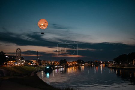Balon na gorące powietrze nad Wisłą w Krakowie o zmierzchu, magiczna atmosfera miasta o zmierzchu
