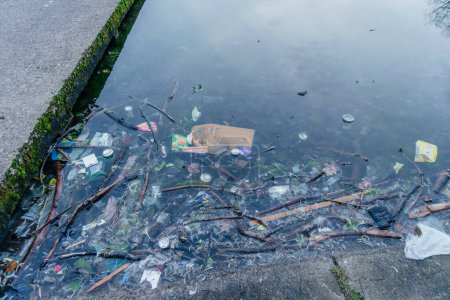 Litter Pollution in Urban Waterway, a variety of trash items including plastic bags, cans, and other debris floating in an urban waterway, the environmental challenges in our city landscapes