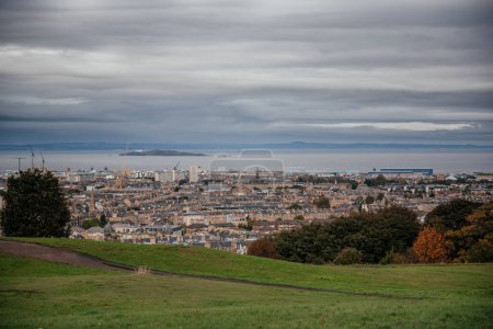 A panoramic view of Edinburgh cityscape with the ocean in the background, suitable for illustrating travel and urban landscape concepts