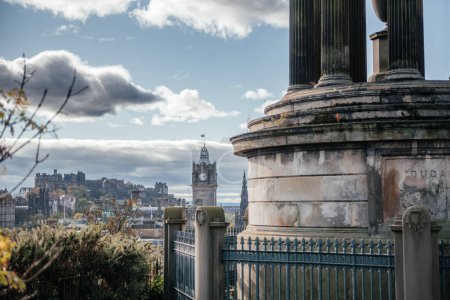 A scenic view of Edinburghs skyline featuring iconic landmarks such as Edinburgh Castle and the Balmoral Clock Tower, seen from Calton Hill