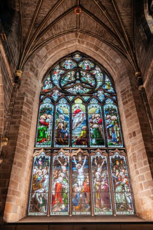 Eine detaillierte Ansicht des wunderschönen Glasfensters in der St. Giles Cathedral in Edinburgh, das komplexe religiöse Kunst zeigt