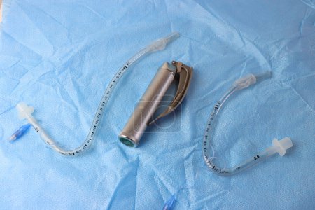 Foto de Tubo especial conocido como RAE nasal y oral utilizado en cirugías de nariz y mes por encima de una superficie quirúrgica con laringoscopio - Imagen libre de derechos
