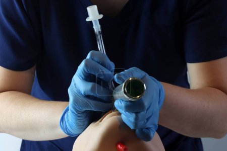 Foto de Intubando a un paciente simulado con un laringoscopio y un tubo endotraqueal. Profesional de la salud con guantes y exfoliantes quirúrgicos. - Imagen libre de derechos