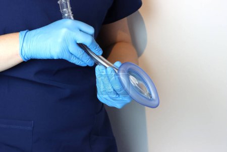 Foto de Máscara laríngea de las vías respiratorias (LMA) en un profesional sanitario que usa guantes quirúrgicos y exfoliaciones quirúrgicas - Imagen libre de derechos