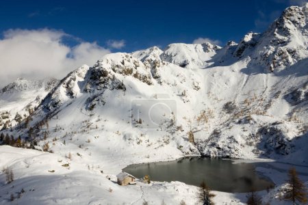 Schöner kleiner alpiner See in Winterlandschaft. Erdemolo-See