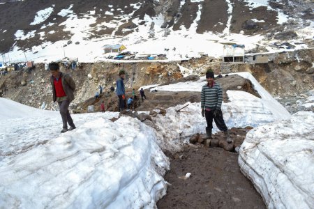 Photo for Rudarprayag, Uttarakhand, India, May 18 2014, Laborer reopening Kedarnath trek locked by snowfall. Kedarnath is ancient and magnificent temple is located in the Rudra Himalaya range, is over a - Royalty Free Image