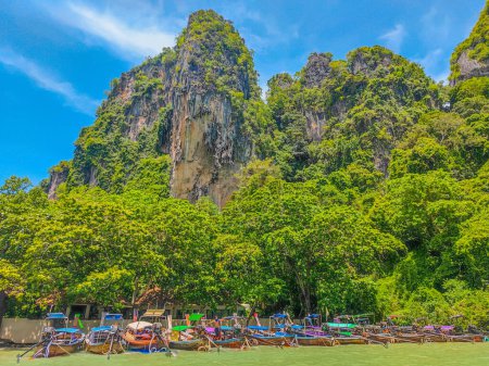 Photo for Thai traditional wooden long tail boats parked on tropical Railay beach in Thailand, Krabi province.The only type of transportation to reach the beach - Royalty Free Image