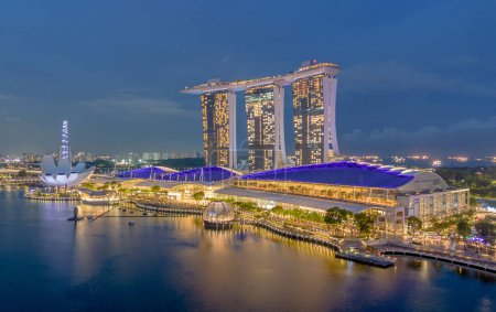 Foto de Vista aérea del paisaje urbano de Singapur al anochecer. Paisaje de Singapur Bahía Marina con edificios modernos y rascacielos por la noche - Imagen libre de derechos