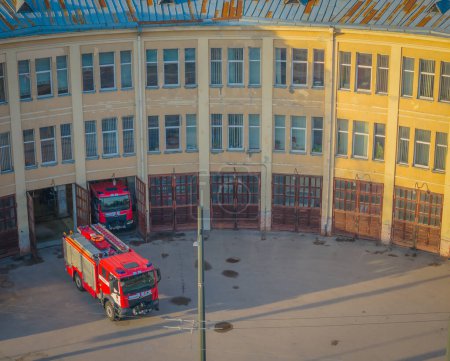 Luftaufnahme des alten und einzigartigen Feuerwehrgebäudes mit Feuerwehrfahrzeugen im Hof der Altstadt von Kaunas, Litauen